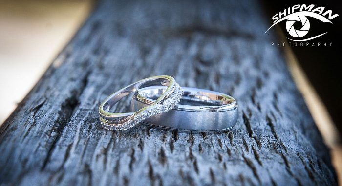 Two wedding rings on a wooden rail
