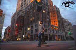 a young man's senior portrait on a street corner in downtown Tulsa