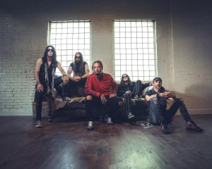 The band Saliva, sitting in an old warehouse on a couch
