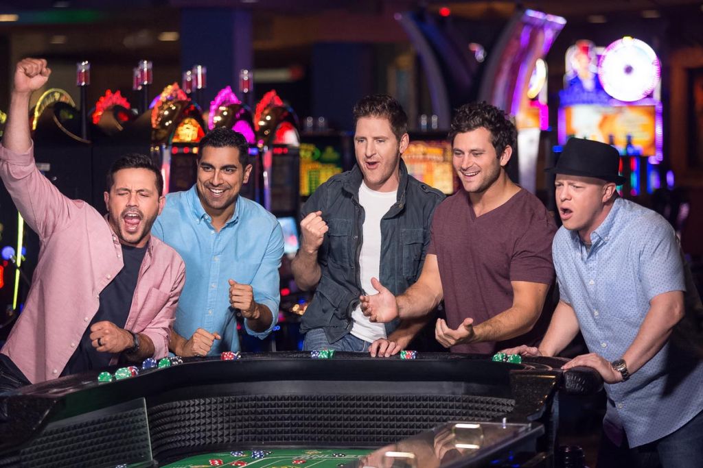 group of guys at the casino, laughing and rolling dice - professional photography advertising tulsa