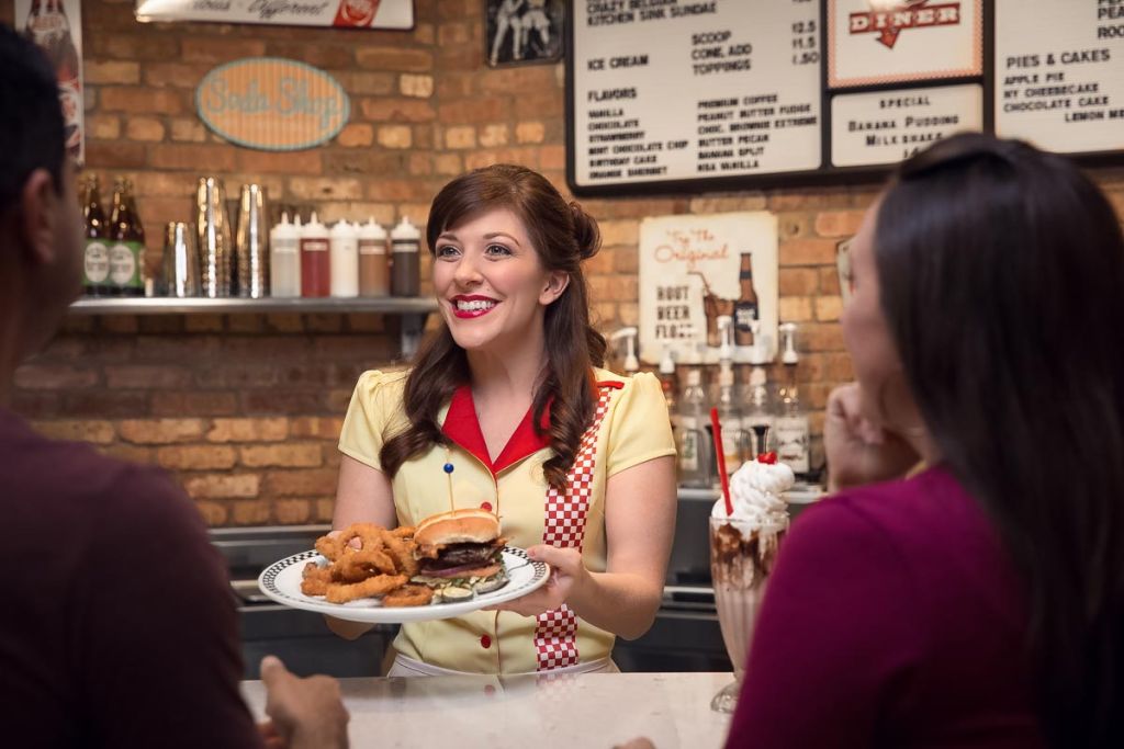waitress serving a hamburger to diner patrons at hard rock tulsa commercial photography