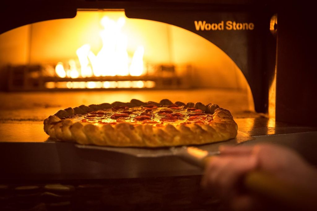pizza going in brick oven at hard rock tulsa food photography