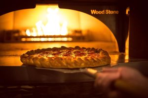 pizza going in brick oven at hard rock tulsa food photography
