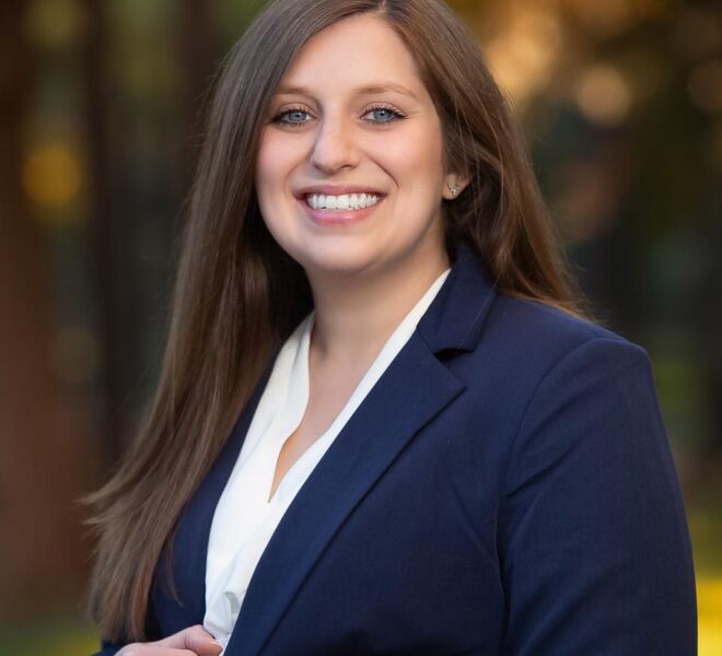 female businesswoman in blue jacket and white top smiles for outdoor fall foliage portrait