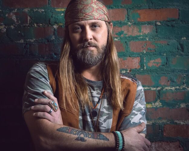 Tulsa musician Travis Bond posing for branding headshot on location in an old Tulsa warehouse