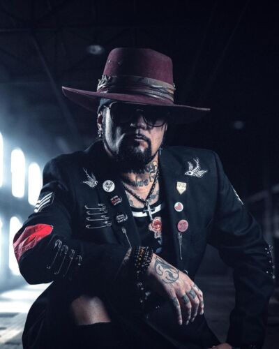 rockstar musician posing for a branding headshot in a dark tulsa warehouse