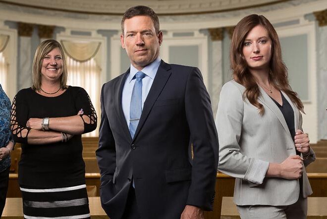 team composite of a law office staff standing in a courtroom