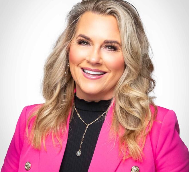 Pretty blonde businesswoman in a black sweater and pink coat, laughs and smiles on a white background during