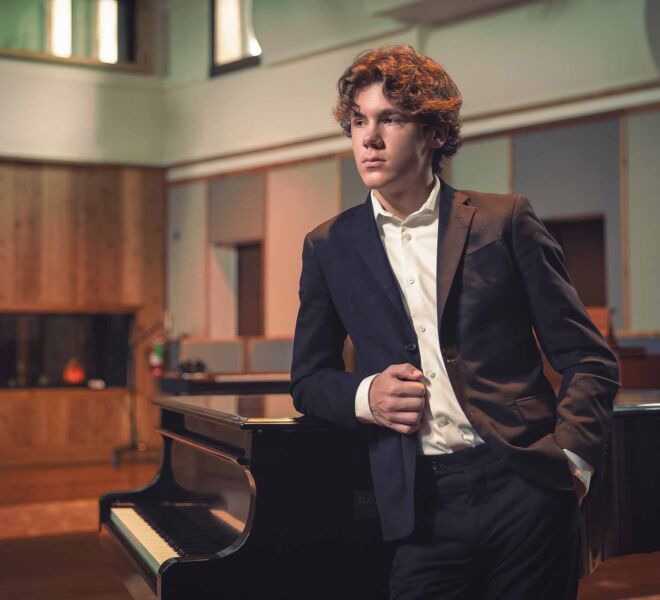 young man in a recording studio, wearing a suit