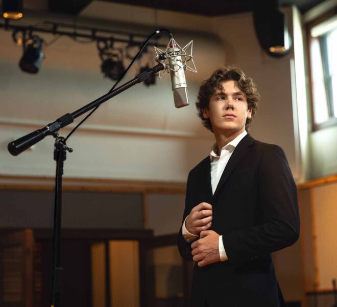 young man in a suit, singing at the Church recording studio in Tulsa