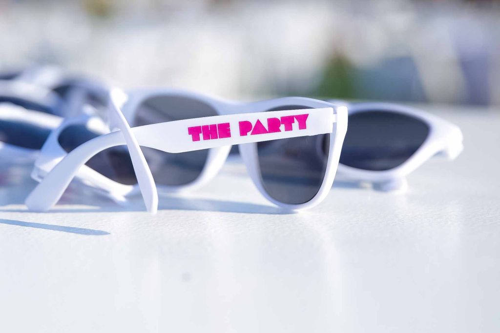 White sunglasses on a white table. Text says "The Party" to celebrate fundraiser event photography tulsa