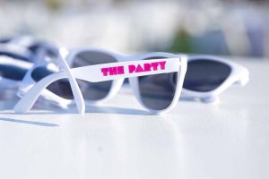 White sunglasses on a white table. Text says "The Party" to celebrate fundraiser event photography tulsa