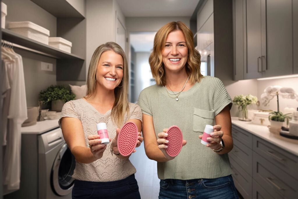 two smiling young women holding their stain cleaning product, small business product photography in tulsa