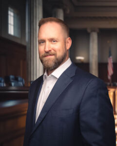 Tulsa attorney in a suit with no tie, smiling in a courtroom