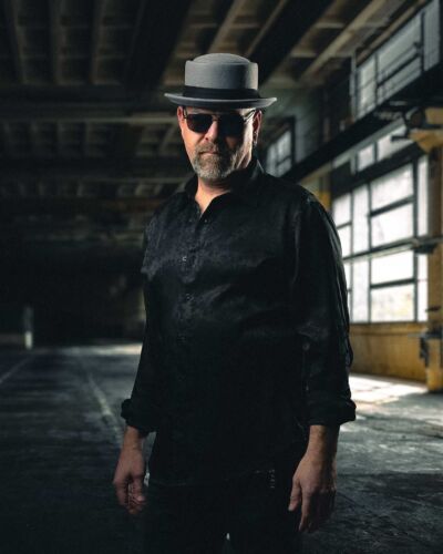 Musician waring black in an alleyway