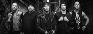 Black and white photo of a rock band in a dark city alleyway.