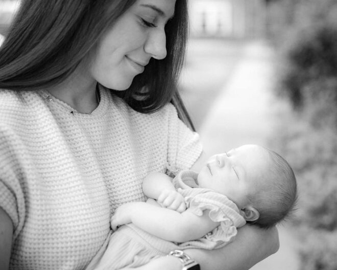 beautiful young mother smiles at her sleeping baby in Broken Arrow