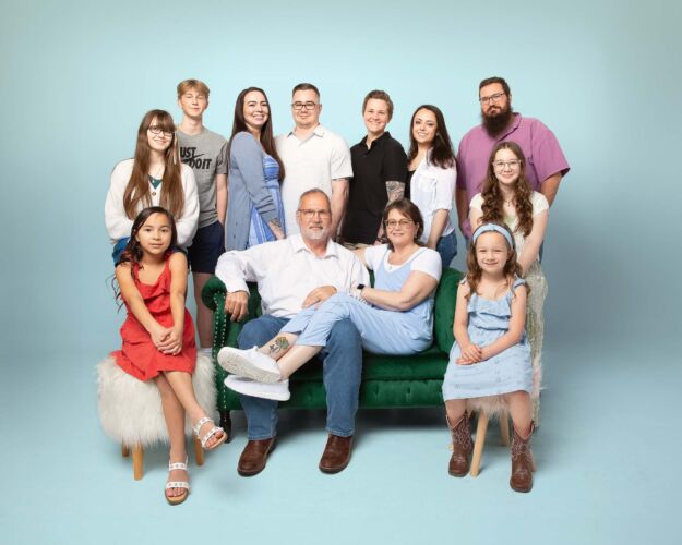 family posing together on a blue studio background