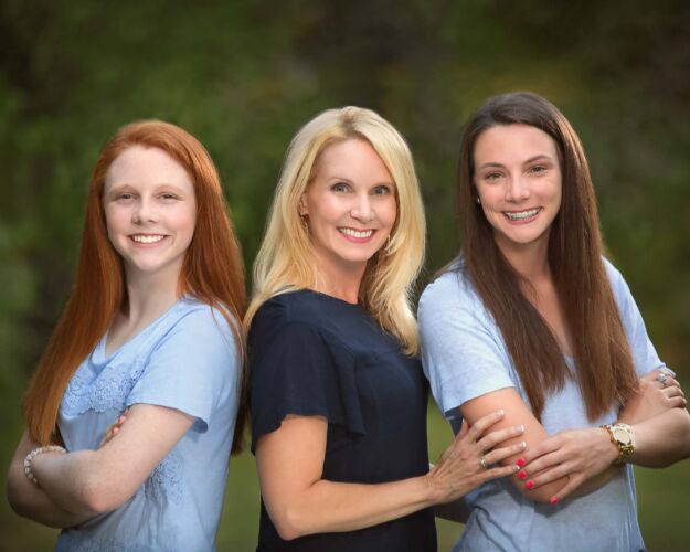 Mother with two daughters posing at the park for family photos