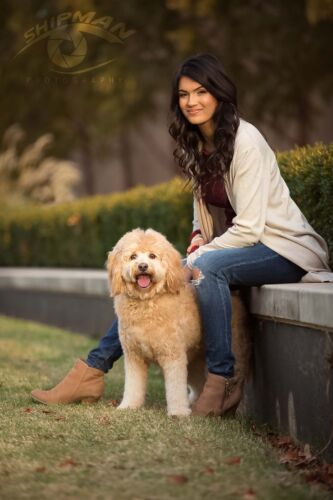beautiful young woman and her dog pose for photos in the park