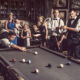 Family playing pool in vintage aesthetic.