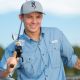 handsome young man smiling with a fishing pole