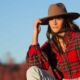 Young woman in a cowboy hat and pullover at sunset