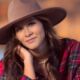 Beautiful smiling native girl in hat by the lake, posing for senior photo in Bixby