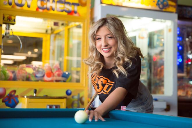 Smiling young woman playing pool