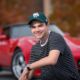 Young man with his red corvette