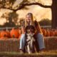 young woman and her dog hanging out in a pumpkin patch