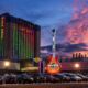 near ground level drone shot hard rock tulsa at sunset big guitar in front of hotel