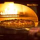 pizza going in brick oven at hard rock tulsa food photography