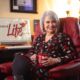 counselor sitting in office chair with big smile, holding cup of coffee professional advertising photography tulsa