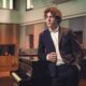 young man in a recording studio, wearing a suit