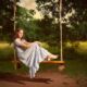 pretty senior girl on rope swing in vintage dress