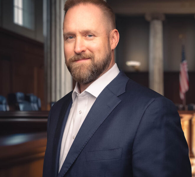 Tulsa attorney in a suit with no tie, smiling in a courtroom