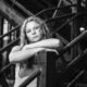 black and white of a young woman leaning on a stair rail