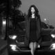Young woman standing in front of a car
