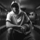 young man in hoodie sitting in basketball locker room